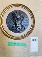 Framed bronze roundel plaque with maxsold tag and diameter note