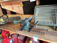 Chainsaw bar, hedge trimmer body and GE heater on shelf