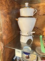 Full view of urn on stand with teapot and lid