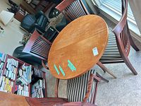 overhead view of round wood veneer table with four slat-back chairs