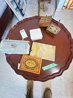 Top view of scalloped mahogany side table with trinket boxes displayed