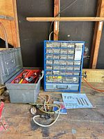 parts organizer, toolbox with hand tools, loose cords and hardware on workbench