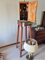 Whole lot showing microscope in case on wooden pedestal with lamp beside
