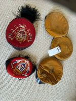 Top view of red fez and gold pillbox cap showing overall design and wear