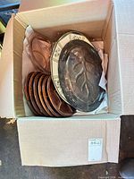 Box containing seven brown divided plates, pink glass relish dish, porcelain platter, and metal tray