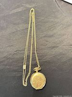 Closed pocket watch with full chain laid flat