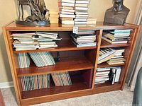 Front view of wood veneer bookshelf filled with books (books not included)