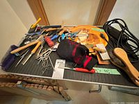 Tabletop view of grooming scissors, brushes, combs, hand tools and corded clipper
