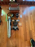 Entire lot laid out: camera, lenses, tripod, meters, cases