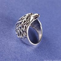 Angled side view of bird head ring showing carved detail and band interior