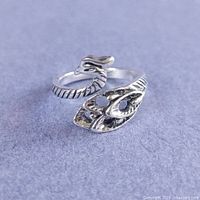 Front view of silver-plated peacock wrap ring showing head and tail design