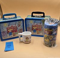 Group shot of two Madeline lunchboxes, melamine cup and sealed stacking cup container