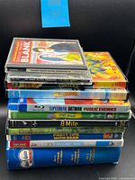 Stacked cases showing titles: Grosse Pointe Blank CD, The Dirty Boogie CD, Madagascar DVD, Superman/Batman Blu-ray, TMNT DVD, 8 Mile DVD, children’s DVDs and Blue’s Clues clamshell