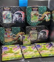 Front view of four tins with promo cards displayed