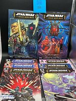 Group shot of two trade paperbacks atop six single comics
