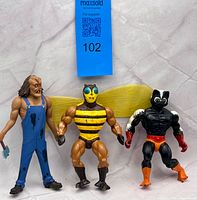 Three action figures standing upright on marble-pattern surface