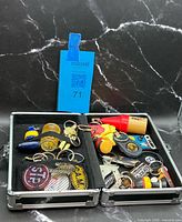 Case open showing assortment of keychains inside mesh pockets