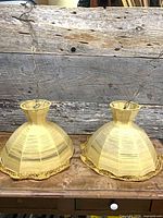 Two matching thread shade pendant lamps on table