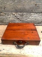 Top view of closed mahogany paint box showing wood grain and clasp