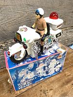 Overall view of toy motorcycle with rider on original box