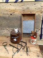 Group shot showing washboard, barrel, jar lifter, trivet, bread knife, canister with shakers, spice tin
