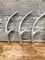 Front view of three identical silver metal coat hooks