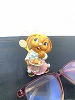 Front view of PenDelfin Crocker rabbit figurine beside glasses for scale