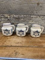 Front view of three matching faience water jugs on table