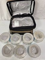 Bag open showing interior and seven wrapped plus one unwrapped tape rolls