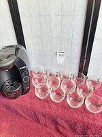 Bosch Tassimo coffee maker beside thirteen glass cups