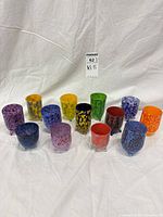 All 13 multicolor speckled glass tumblers displayed upright on white backdrop