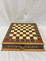 Closed inlaid wood chessboard case with drawer front visible