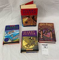 Group shot of four Harry Potter hardcovers with dust jackets laid out on white backdrop