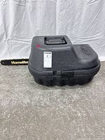 Chainsaw inside closed black Homelite case with bar visible