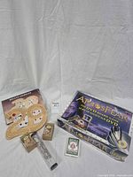 Group shot showing Atmosfear game box, cribbage boards, bamboo puzzles, wire puzzle in tube, Bicycle cards