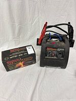 Jump starter with clamps beside original box