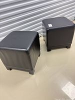 Two black faux leather cube ottomans side by side