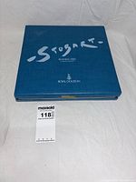 Blue presentation box closed showing artist signature and titles