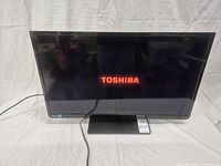 Front view of Toshiba TV powered on showing logo