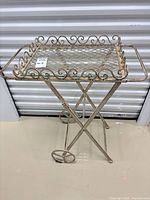 Full view of metal serving cart showing removable tray, handles, legs, and wheels