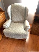 Front view of floral upholstered wingback armchair