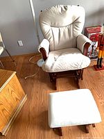Front angled view of glider chair and ottoman showing upholstery and wood frame
