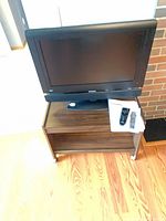 Front view of Prima LCD TV on stand with accessories
