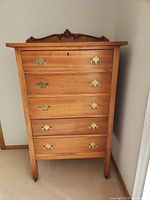 Front view of highboy dresser showing five drawers and brass pulls
