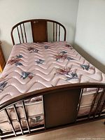 Full view of assembled bed showing wood frame, headboard, footboard, mattress