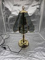 Full view of brass table lamp with glass panels and cord