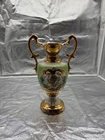 Full view of porcelain vase front showing coloring, gilt, relief medallion