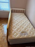 Top view of mattress, topper, headboard and side rail visible