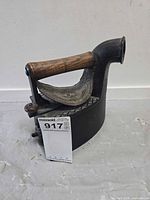 Full view of antique charcoal iron showing body, handle and brass plate
