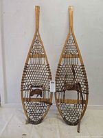 Full view of both wooden snowshoes side by side